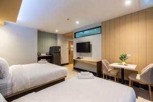 a hotel room with two beds and a television at Hi Sotel - SHA Plus in Makkasan