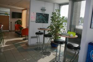 a room with two tables and stools in a room at ibis Budget Thiers in Thiers