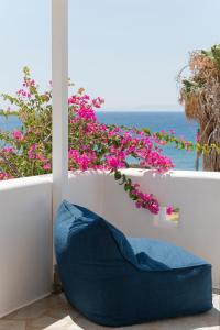 a blue couch in front of a balcony with pink flowers at KAMEO, Antiparos in Antiparos