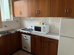 a kitchen with a white microwave and a stove at Regatta Point Holiday Park in Bermagui