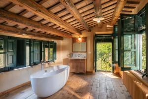 - une grande salle de bains pourvue d'une baignoire et de fenêtres dans l'établissement Flateli Mas Llop, à Sant Climent de Peralta