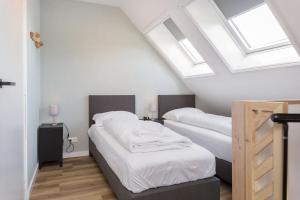 a attic bedroom with two beds and skylights at Paviljoenwei 10, appartement 39 Sneek - Offingawier in Offingawier