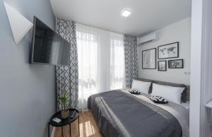 a bedroom with a bed and a flat screen tv at MYFREEDOM Апартаменти метро Нивки in Kyiv