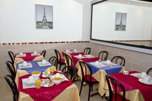 eine Reihe von Tischen in einem Restaurant mit rotem und blauem Tischtuch in der Unterkunft Hipotel Paris Voltaire Bastille in Paris