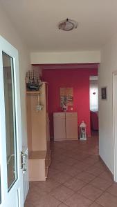 una habitación con una pared roja y una cocina en Apartmani Katatina, en Rab