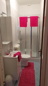 a bathroom with a sink and a shower with pink towels at Apartmani Katatina in Rab