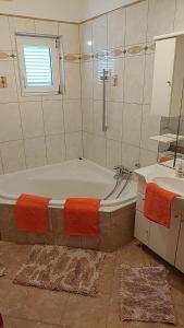 a bathroom with a tub and a sink at Apartmani Katatina in Rab