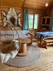 Cette chambre comprend un fauteuil à bascule dans une cabane en rondins. dans l'établissement Metsä Kolo, à Saariharju