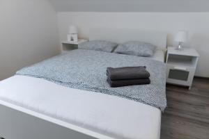 un letto bianco con una borsa marrone sopra di Olivér 22 Apartman a Fonyód