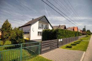 a fence in front of a white house at Olivér 22 Apartman in Fonyód