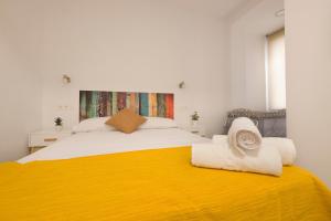 sypialnia z dużym łóżkiem i żółtym kocem w obiekcie Apartamento Ribera del Genil Centro w Grenadzie