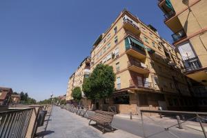 格拉納達的住宿－Apartamento Ribera del Genil Centro，前面有长凳的建筑