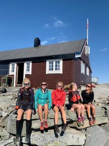 a group of women sitting in front of a building at Nes Gard in H&oslash;yheimsvik