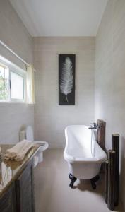 a bathroom with a white tub and a bird picture on the wall at Le Comfort (self catering) in Anse Royale