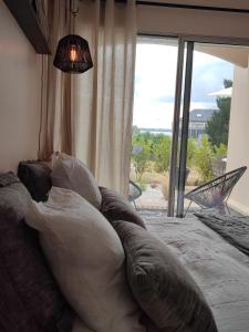 sypialnia z dużym łóżkiem i dużym oknem w obiekcie Le 3 appartement vue mer avec jardin 100m de la plage et de la thalasso w mieście Concarneau +31 zdjęć
