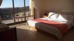 a bedroom with a bed and a balcony with a view at Jerusalem Hotel Lalibela in Lalibela