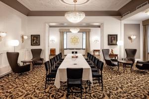 een vergaderzaal met een lange tafel en stoelen bij Classic Hotel Meranerhof in Merano