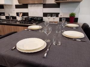 a table with plates and wine glasses on it at Rome 66 apartments in Rome