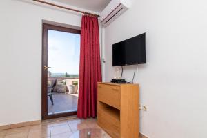a living room with a tv and a window at Apartment Slavica with private Balcony and Parking lot in Punat