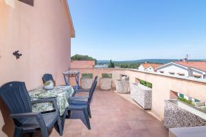 a patio with a table and chairs on a balcony at Apartment Slavica with private Balcony and Parking lot in Punat