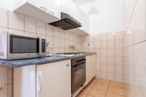 a kitchen with a microwave and a stove at Apartment Slavica with private Balcony and Parking lot in Punat