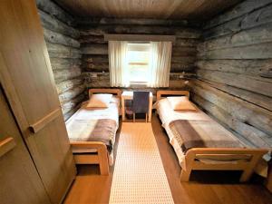 a room with three beds in a log cabin at Kelo / Lapland, Saariselkä in Saariselka