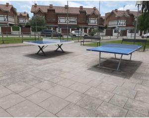 dos mesas de ping pong sentadas en un estacionamiento en Apartamento con jardin privado y piscina, en Cirueña