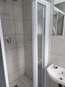 un baño con ducha y lavabo en Grace Villas 7, en East London