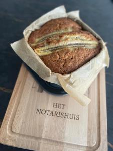 um pedaço de pão sentado numa tábua de cortar em B&B het Notarishuis em Voeren