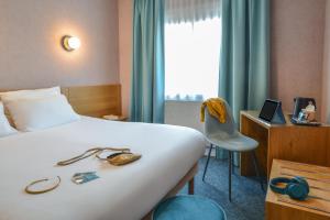 a hotel room with a bed and a window at Sure Hotel by Best Western Centre Beaune in Beaune