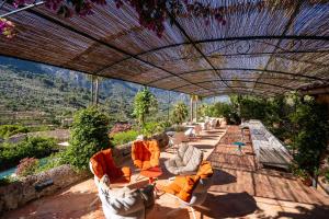 a group of lounge chairs under an umbrella on a patio at Hotel Can Verdera in Fornalutx