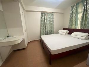 a small bedroom with a bed and a sink at The Palm Guest House in Kohīma