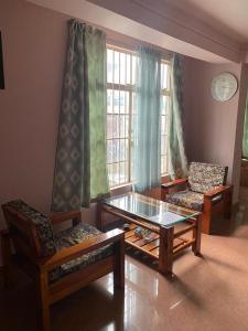 - un salon avec deux chaises et une table en verre dans l'établissement The Palm Guest House, à Kohīma