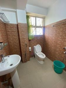 La salle de bains est pourvue d'un lavabo et de toilettes. dans l'établissement The Palm Guest House, à Kohīma