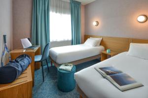 a hotel room with two beds and a desk at Sure Hotel by Best Western Centre Beaune in Beaune