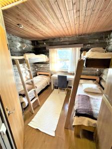 a room with three bunk beds and a desk at Kelo / Lapland, Saariselkä in Saariselka