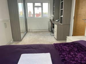 a bedroom with a purple bed and a desk at Deluxe Homestay near Tottenham Hotspur Stadium in London