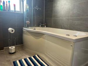 y baño con bañera y lavamanos. en Deluxe Homestay near Tottenham Hotspur Stadium en Londres