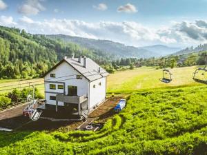 eine Luftaufnahme eines Hauses auf einem grünen Feld in der Unterkunft Willa Monte in Wisła