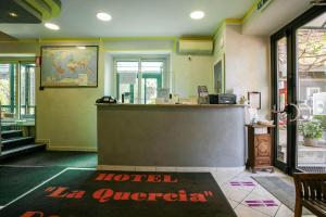 un vestíbulo de hotel con una señal de hotel la guerrero en el mostrador en Hotel La Quercia, en Mozzo