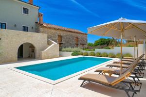 an image of a swimming pool with chairs and an umbrella at Villa Vitassi in Pula