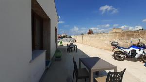 a motorcycle parked on a patio with tables and chairs at Villa Saponaro - Affittacamere in Torre Lapillo