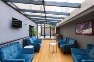 a waiting room with blue chairs and a skylight at Numa Prague Root in Prague
