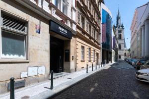 a cobblestone street in a city with buildings at Numa Prague Root in Prague