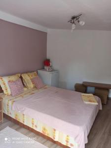 - une chambre dotée d'un grand lit avec des draps et des oreillers roses dans l'établissement Casa Calix, à Băile Govora
