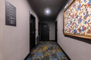 a hallway with a painting of flowers on the wall at Numa Prague Root in Prague