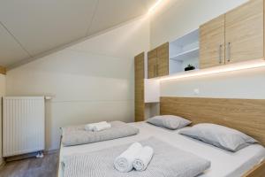 a bedroom with two beds with towels on them at Three Stars Luxury House ART-PE with pool and SPA pool in Trebnje