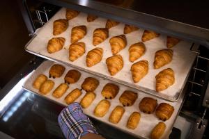 a person is taking bread out of an oven at Hotel Axia Inn Sapporo Susukino in Sapporo