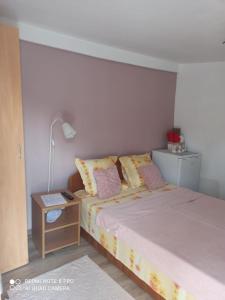 - une petite chambre avec un lit et une table de nuit dans l'établissement Casa Calix, à Băile Govora
