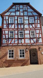 a half timberedbered house with a large door at Brunnenputzer Pension Restaurant in Külsheim